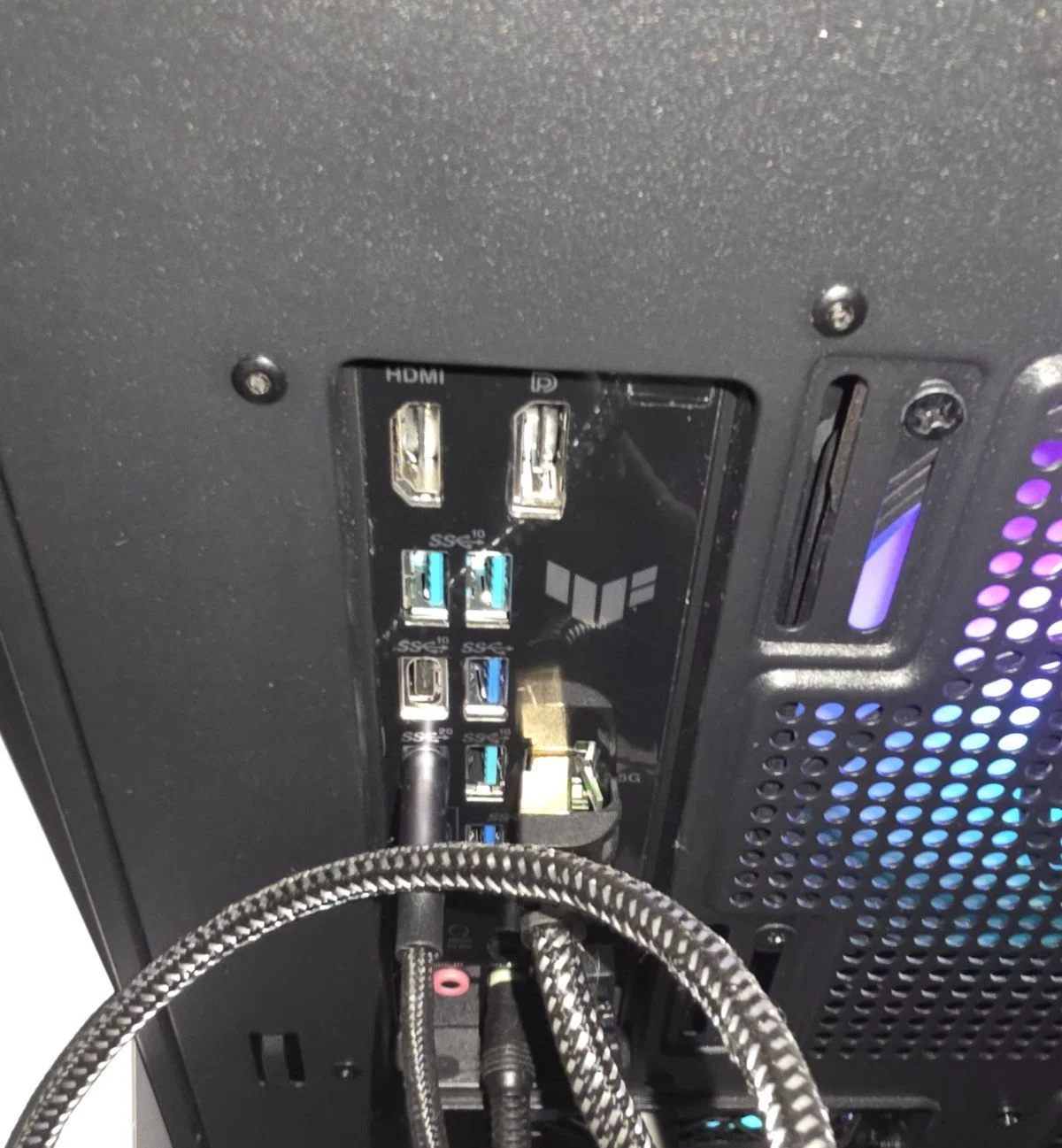 본체 뒷면의 메인보드 단자 부분, HDMI·DP·USB 단자 둘레를 검은 판이 감싸고 있고 랜선과 USB 선이 꽂혀 있다